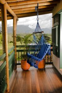 a hammock hanging on a porch with a view at Hacienda Bambusa in El Caimo