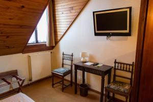 a room with two chairs and a television on the wall at Logis Hôtels Restaurant Le Relais Chenonceaux in Chenonceaux