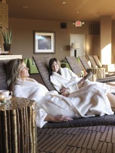 two women sitting on a couch in a hotel room at Red Mountain Resort in St. George