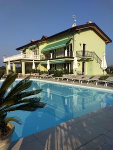 a villa with a swimming pool in front of a building at Residenza Pastrengo in Pastrengo