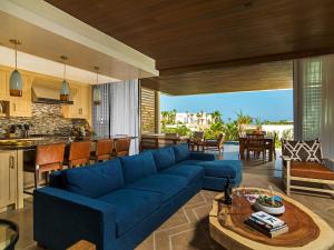 uma sala de estar com um sofá azul e uma cozinha em Chileno Bay Resort & Residences, Auberge Collection em Cabo San Lucas