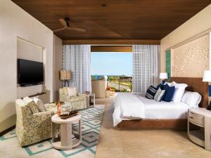 um quarto de hotel com uma cama e uma sala de estar em Chileno Bay Resort & Residences, Auberge Collection em Cabo San Lucas mais 64 fotografias