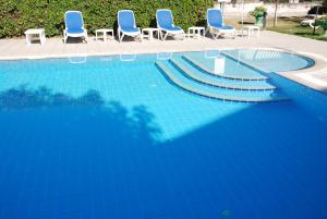 a blue swimming pool with blue chairs and chairs at Hotel Andreis in Cavaion Veronese
