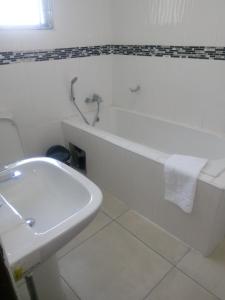a bathroom with a sink and a tub and a toilet at Eros Guest Inn in Francistown