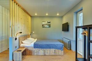 カリーニングラードにあるKosmicheskaia 22-18のベッドルーム1室(木製ヘッドボード付きのベッド1台付)