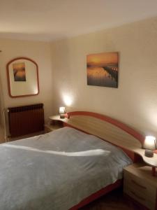 a bedroom with a bed with two lamps and a bridge at Gostilna Tratnik in Zoll