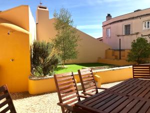 eine Terrasse mit einem Tisch und Stühlen sowie einem Hof in der Unterkunft Apartments Center Castelo de São Jorge in Lissabon