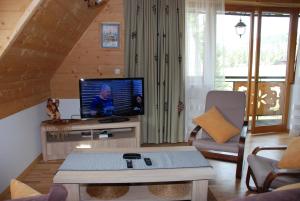 sala de estar con TV en una mesa en Apartament Lux Czerwone Korale, en Kościelisko