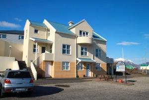 un bâtiment avec une voiture garée devant lui dans l'établissement Guesthouse Hvammur, à Höfn