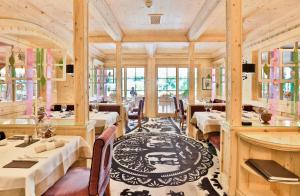 a restaurant with tables and chairs in a room at ERMITAGE Wellness- & Spa-Hotel in Gstaad