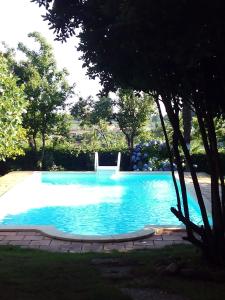 una gran piscina azul con una silla. en Casa Rural Donatila, en Villasbuenas de Gata