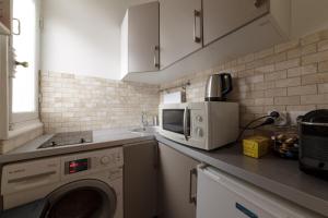 a kitchen with a washing machine and a microwave at Private Studio - Avenue des Champs-Elysées in Paris