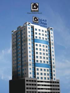a tall building with a sign on top of it at Al Olaya Suites Hotel in Manama