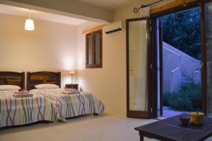 a bedroom with two beds and a sliding glass door at Mastrogiannis Villa Levanda in Kavvadádes