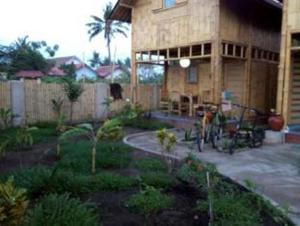 a house with a bike parked in front of it at Little Woodstock Homestay in Gili Trawangan