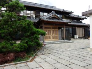 uma casa asiática com um pinheiro em frente em Minpaku Nagashima room3 / Vacation STAY 1035 em Kuwana