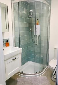 y baño con ducha y lavamanos. en Corner House Luxury BnB, en Little Dunmow