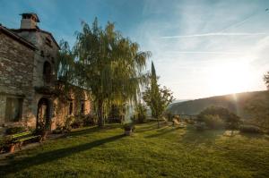 バルベリーノ・ディ・ヴァル・デルサにあるAgriturismo Montecorboliの庭に木が植えられた古い石造りの建物