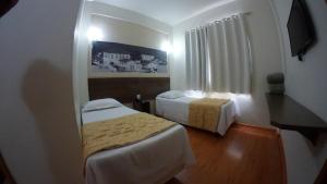 Łóżko lub łóżka w pokoju w obiekcie Hotel Pit Stop Oliveira-MG