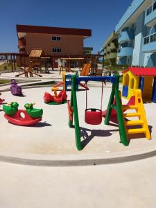 einen Spielplatz mit Schaukel und anderen Spielgeräten in der Unterkunft Golden Lake Residence in Arraial do Cabo