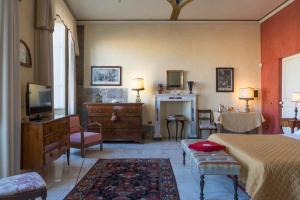 una camera con letto, TV e camino di Luxory suite su Lungarno a Pisa