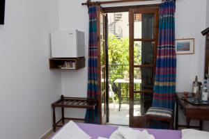 a room with a door open to a patio with a table at Pegasus Hotel in Pythagoreio