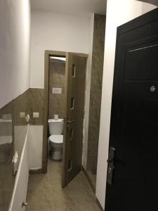 a bathroom with a toilet and a open door at Regim Hotelier Pietonală in Oradea