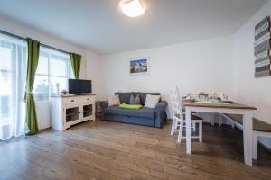 ein Wohnzimmer mit einem Tisch und einem Sofa sowie ein Esszimmer in der Unterkunft Ninas Residenzerl in Kolsassberg