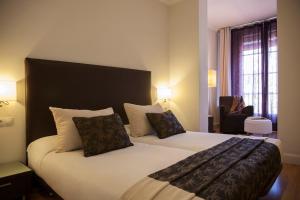 una camera d'albergo con letto e sedia di Hostal Goya a Barcellona