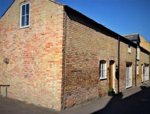 a red brick building with windows on a street at The Old Bottle Store - 2 Double Bedrooms, 2 Bathrooms, St Ives, Cambridgeshire in St. Ives