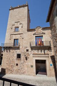 un alto edificio in mattoni con due finestre e un balcone di Parador de Caceres a Cáceres