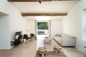 a living room with a couch and a tv at Les Amandiers in Bonnieux