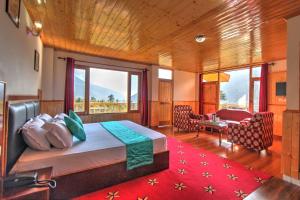 a bedroom with a bed with a red rug at Hotel Mountain face by Snow City Hotels in Manāli