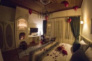 a bedroom with a bed and a fireplace and a chandelier at BAYEZİD HAN KONAK in Amasya