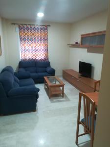 un soggiorno con divano blu e tavolo di Apartamento Pergar II Alojamiento para empresas-WIFI 4 Personas a Las Gabias