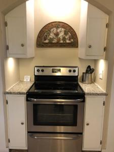 a kitchen with a stove and white cabinets at Sunset Inn and Suites in Fredericksburg
