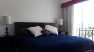 a bedroom with a blue bed with two pillows at Apartamento Pelicanos, Nuevo Vallarta in Nuevo Vallarta