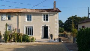 a large white house with a black door at la bouquetiere in Mazières-en-Gâtine
