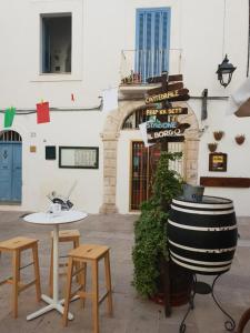 a building with a table and two chairs and a barrel at Orazio33 b&b in Monopoli
