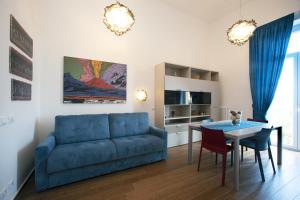 un soggiorno con divano blu e tavolo di Italia Apartment OrtoBotanic Garden a Napoli