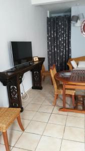 a living room with a table and a television at Le Rêve Bleu in Dumbéa