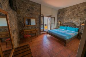 a bedroom with a bed and a table and a mirror at Hotel Rural Huerto Viejo in Tesejerague +19 photos
