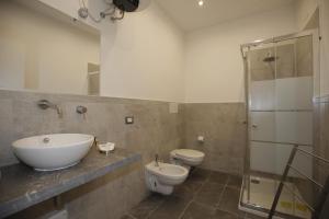 ein Badezimmer mit einem Waschbecken, einem WC und einem Spiegel in der Unterkunft Belle Arti in Palermo