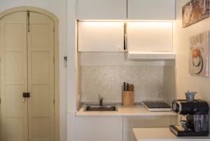 a kitchen with white cabinets and a sink at Suite Plaza de la Laguna by Dulce in Ayamonte