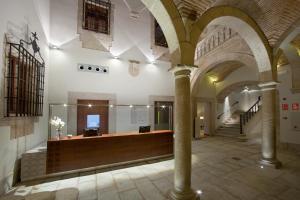 a lobby with a reception desk in a building at Parador de Caceres in Cáceres