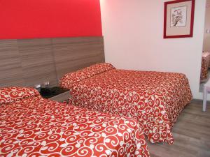 two beds in a hotel room with red walls at Hotel Dharma in Mexico City