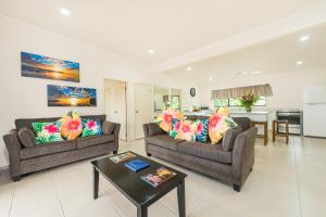 Sala de estar con 2 sofás y mesa en Cook Islands Holiday Villas - Turangi Lagoon en Muri