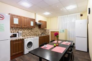 a kitchen with a table and a white refrigerator at Semenovskiy Mini Hotel in Moscow