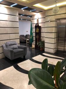a lobby with a couch and a clock in it at Shamat Jeddah Furnished Units in Jeddah