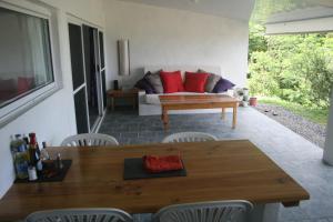 uma sala de estar com um sofá, uma mesa e cadeiras em océan studio em Tevaitoa